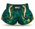 Green and gold IMPACT Muay Thai shorts with traditional curved high-cut hems and IMPACT waistband patch