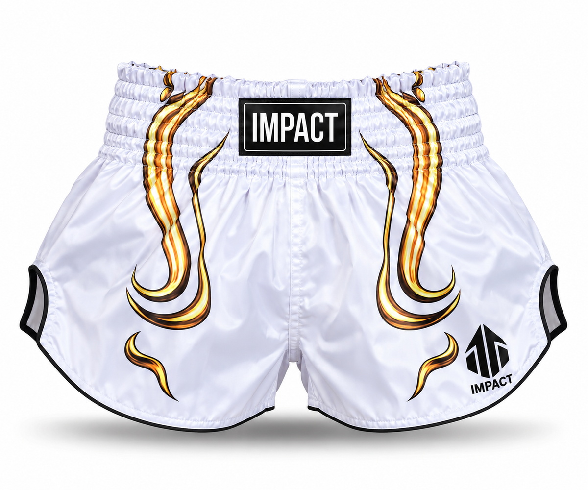 White and gold IMPACT Muay Thai shorts with high-curved hems, side slits and centered IMPACT waistband branding