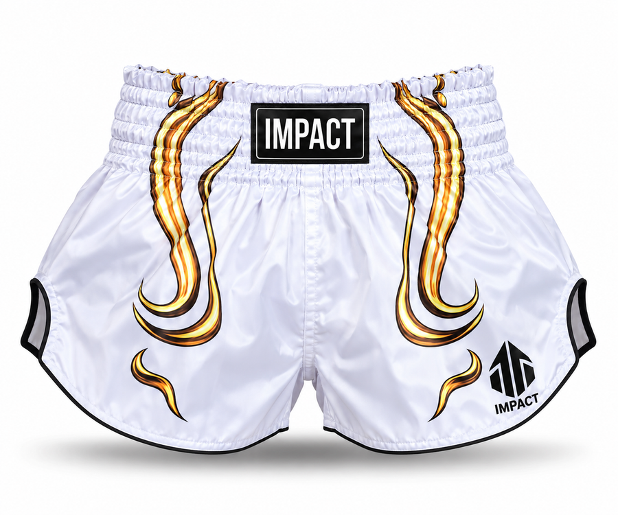 White and gold IMPACT Muay Thai shorts with high-curved hems, side slits and centered IMPACT waistband branding